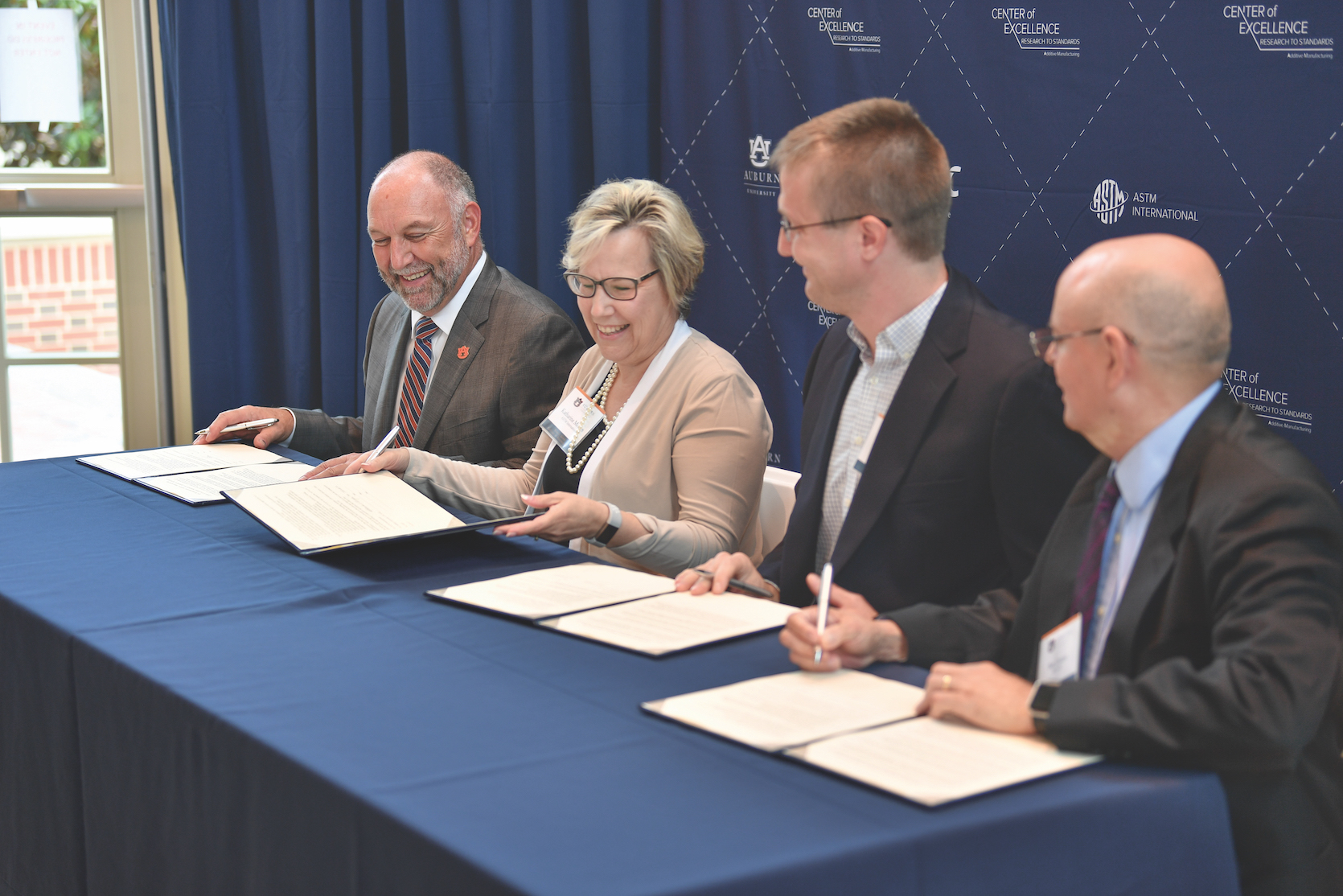 Participants signing the ASTM International Additive Manufacturing Center of Excellence Statement on Cooperative Agreement. From left: Auburn University President Steven Leath; ASTM International President Katharine Morgan; Alex Kitt, Product Manager, EWI Buffalo Manufacturing Works; and Benjamin Dutton, Manufacturing Technology Centre.